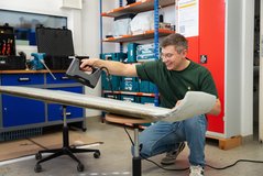 Junger Mann arbeitet mit einem Werkzeug in der Werkstatt